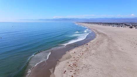 An-Excellent-Vista-Aérea-Shot-Shows-People-Walking-Along-The-Surf-On-A-Beach-In-Oxnard-California