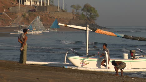 Jungs-Schieben-Ein-Fischerboot-Im-Katamaranstil-In-Indonesien-Ans-Ufer-Shore