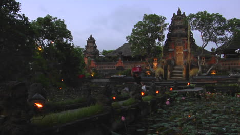 Eine-Frau-Geht-Auf-Dem-Gelände-Eines-Balinesischen-Tempels-Spazieren-Und-Trägt-Einen-Korb-Auf-Dem-Kopf