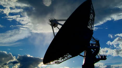 A-Satellite-Dish-Moves-In-Time-Lapse-And-Is-Silhouetted-Against-The-Sky