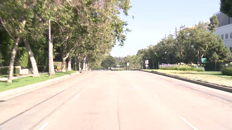 Ein-Auto-Fährt-Eine-Straße-In-Der-Jahrhundertstadt-Los-Angeles-Entlang,-Gesehen-Durch-Die-Heckscheibe-1