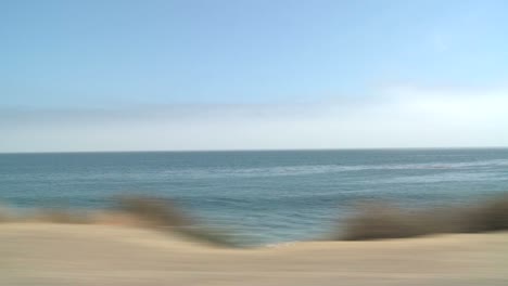 A-Car-Travels-Along-Pacific-Coast-Highway-As-Seen-Through-The-Side-Window-9