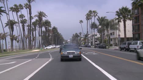 Ein-Auto-Fährt-Eine-Straße-In-Santa-Monica-Kalifornien-Entlang,-Gesehen-Durch-Die-Hintere-Scheibe-3