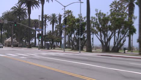 Ein-Auto-Fährt-Entlang-Einer-Küstenstraße-In-Santa-Monica,-Kalifornien,-Wie-Durch-Die-Heckscheibe-Schräg-Gesehen