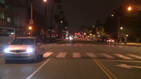 Ein-Auto-Fährt-Nachts-Eine-Straße-In-Santa-Monica-Kalifornien-Entlang,-Gesehen-Durch-Die-Hintere-Scheibe