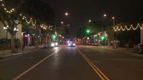 Un-Automóvil-Viaja-Por-Una-Calle-De-Noche-En-Santa-Mónica,-California,-Visto-A-Través-De-La-Ventana-Trasera-3