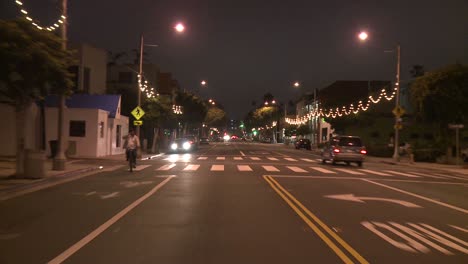 Un-Automóvil-Viaja-Por-Una-Calle-De-Noche-En-Santa-Mónica,-California,-Visto-A-Través-De-La-Ventana-Trasera-5