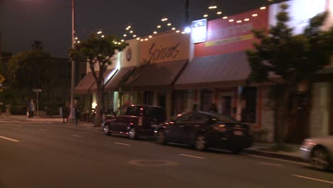 Ein-Auto-Fährt-Nachts-Eine-Straße-In-Santa-Monica-Kalifornien-Entlang,-Gesehen-Durch-Die-Hintere-Scheibe-Schräg
