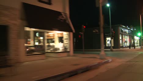 Ein-Auto-Fährt-Nachts-In-Los-Angeles-Eine-Straße-Entlang,-Schräg-Durch-Die-Heckscheibe-Gesehen