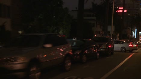 Ein-Auto-Fährt-Nachts-Eine-Straße-In-Los-Angeles-Kalifornien-Entlang,-Wie-Durch-Die-Heckscheibe-In-Einem-Winkel-Von-4-.-Gesehen