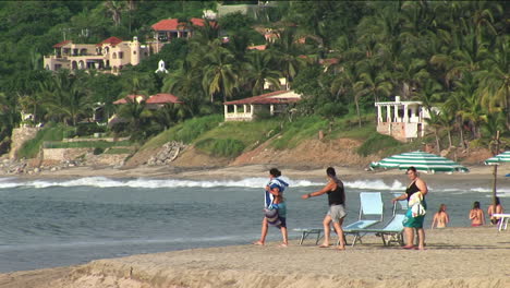 Tres-Personas-Caminan-Hacia-El-Agua-En-Un-Resort-De-Playa