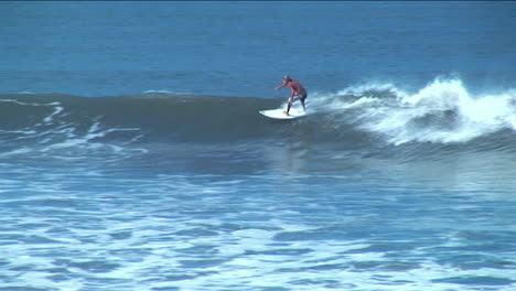 Un-Surfista-Recorre-El-Curso-De-Una-Ola-De-Superficie-Larga-Antes-De-Desaparecer