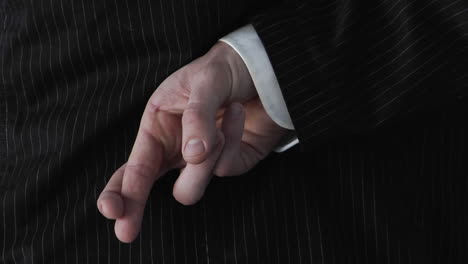 A-businessman-crosses-his-fingers-behind-his-back