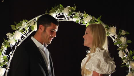 Bride-and-groom-laughing-under-a-flower-arch