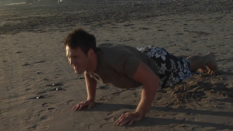 A-man-does-pushups-on-a-sandy-beach
