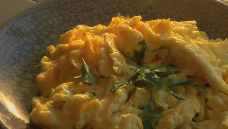 A-slow-pull-into-a-bowl-of-scrambled-eggs-as-parsley-is-chopped-1