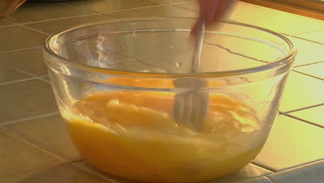 Raw-eggs-are-stirred-in-a-glass-bowl