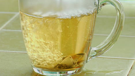 Kochendes-Wasser-übergossen-über-Einen-Teebeutel-In-Einer-Klaren-Glaskaffeetasse
