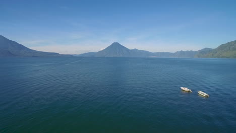 Aerial-over-a-boat-dock-on-Lake-Amatitlan-in-Guatemala-reveals-the-Pacaya-Volcano-in-the-distance