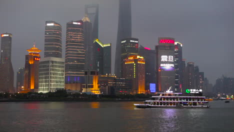 Die-Nachtskyline-Von-Shanghai-China-Mit-Flussverkehr-Im-Vordergrund-1