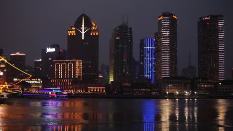 Die-Nächtliche-Skyline-Von-Shanghai-China-Mit-Flussverkehr-Vordergrund-Und-Beleuchtetem-Großsegler-Vorbei-An-3