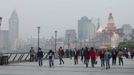 People-walk-on-a-broad-promenade-on-the-waterfront-of-Shanghai-China