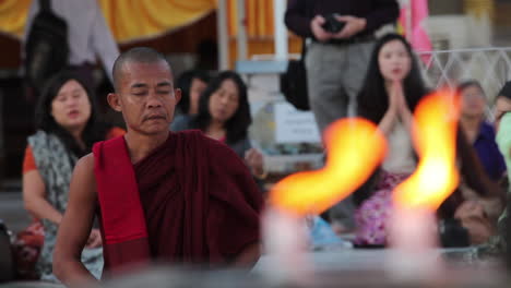 Ein-Burmesischer-Mönch-Betet-In-Einem-Buddhistischen-Tempel-Mit-Kerzenvordergrund