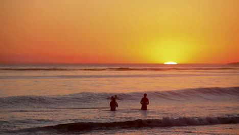 People-gather-and-play-in-the-ocean-at-sunset-1