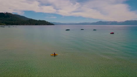 An-aerial-over-a-woman-paddling-a-kayak-across-Lake-Tahoe-1