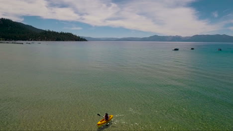 Eine-Antenne-über-Einer-Frau,-Die-Mit-Einem-Kajak-über-Den-Lake-Tahoe-Paddelt-3