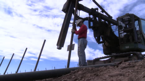 Workers-set-up-a-vineyard-with-stakes-and-poles-and-with-the-aid-of-s-team-shovel