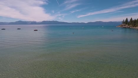 A-woman-in-a-yellow-kayak-paddles-on-the-sunlight-crystal-clear-water-of-Lake-Tahoe-on-a-bright-summer-day-6