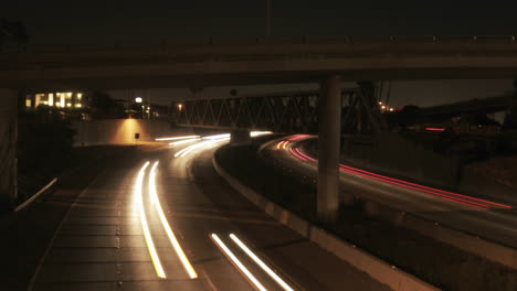 Vehicle-headlights-shine-on-a-freeway-at-night