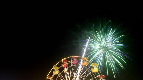 Fireworks-explode-over-a-Ferris-wheel-in-time-lapse