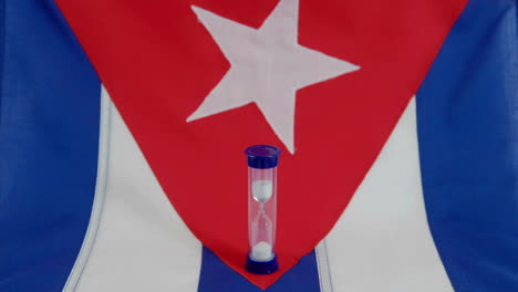 A-Cuban-flag-sits-beneath-a-run-hourglass