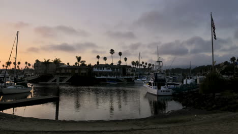Time-lapse-clouds-at-dusk-blowing-over-channel-lined-with-homes-and-boats