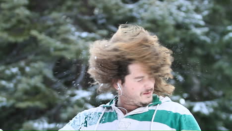 A-young-man-on-a-ski-slope-takes-a-break-to-shake-the-snow-out-of-his-hair-