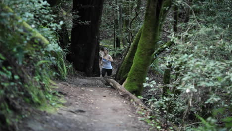Women-enjoying-a-brisk-paced-jog-along-a-dirt-path-in-the-woods