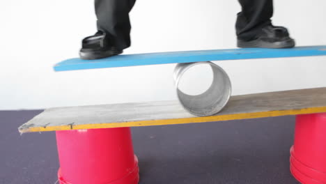A-man-balances-on-a-board-and-a-tube