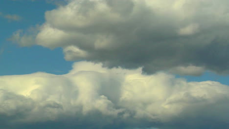Wogende-Weiße-Wolken-Mit-Grauen-Untertönen-Ziehen-Vor-Blauem-Himmel