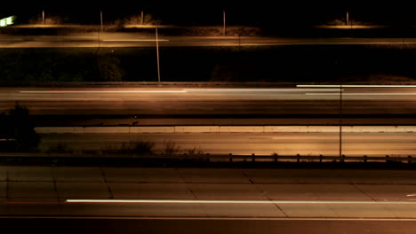 Vehicles-drive-on-a-freeway-at-night-in-fast-motion