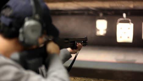 A-man-fires-a-rifle-at-a-target-at-an-indoor-shooting-range
