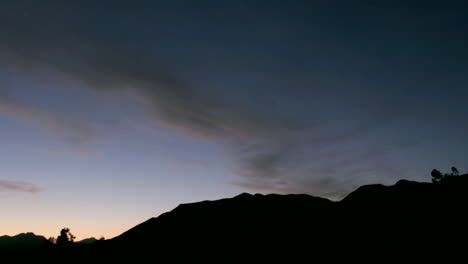Wolken-Ziehen-Während-Der-Goldenen-Stunde-über-Einen-Bergsilhouette