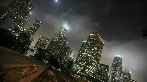 Heavy-traffic-drives-on-a-busy-freeway-in-a-city-at-night-in-downtown-Los-Angeles-with-fog-rolling-in