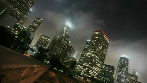 Heavy-traffic-drives-on-busy-streets-at-night-in-downtown-Los-Angeles-with-fog-rolling-in