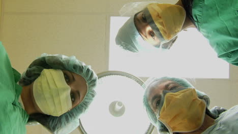 Surgeons-look-down-on-a-patient-and-use-instruments-in-this-POV-shot-1