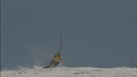 A-skier-skis-around-poles-hitting-one-and-continues-down-a-slope