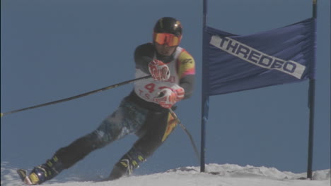A-competitive-skier-passes-a-sign-as-he-skis-downhill