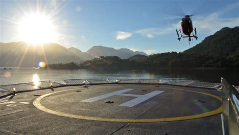Low-angle-of-a-helicopter-landing-on-a-ship-helipad-at-sunrise-near-Chait̩n-in-Northern-Patagonia-in-Chile