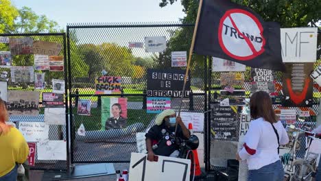 Pedestrians-Stop-To-Talk-To-Black-Lives-Matter-Protestors-And-Read-Their-Posted-Signs-In-Washington-Dc